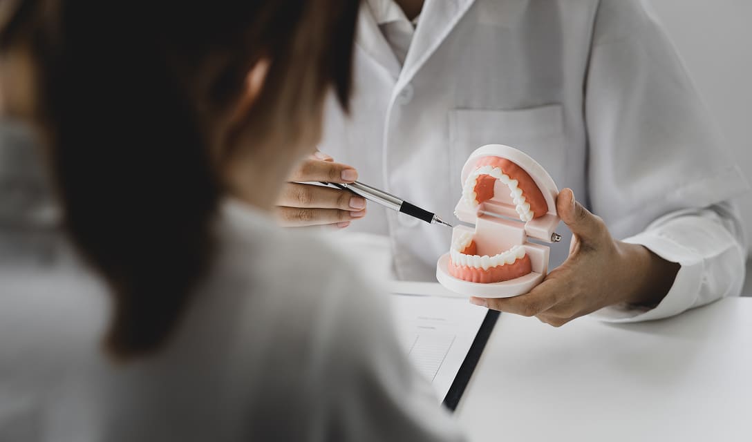 Dentist examining a dental model with an explorer tool